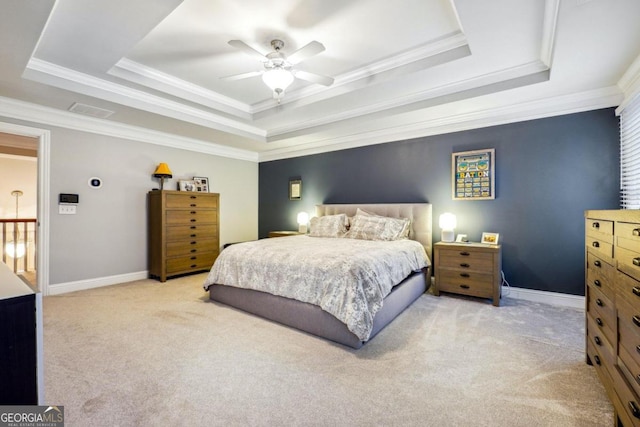 bedroom with ceiling fan, ornamental molding, light carpet, and a tray ceiling