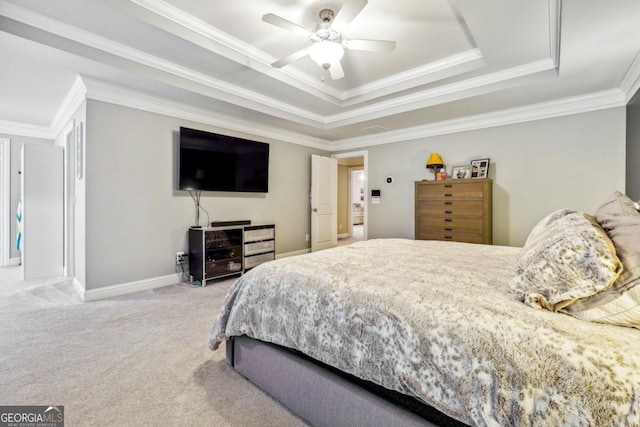 carpeted bedroom featuring a tray ceiling, ceiling fan, and crown molding