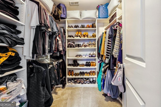 walk in closet featuring light carpet