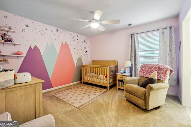 bedroom with a nursery area, ceiling fan, and carpet floors