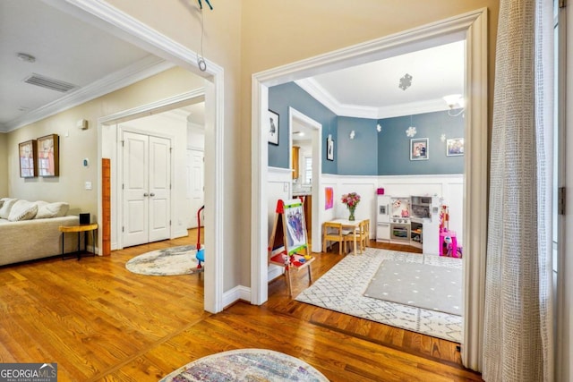 interior space with wood-type flooring and crown molding