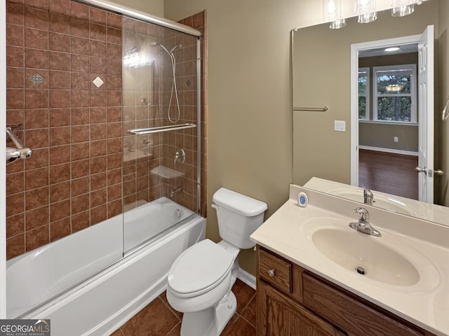 full bathroom featuring tile patterned floors, combined bath / shower with glass door, toilet, and vanity