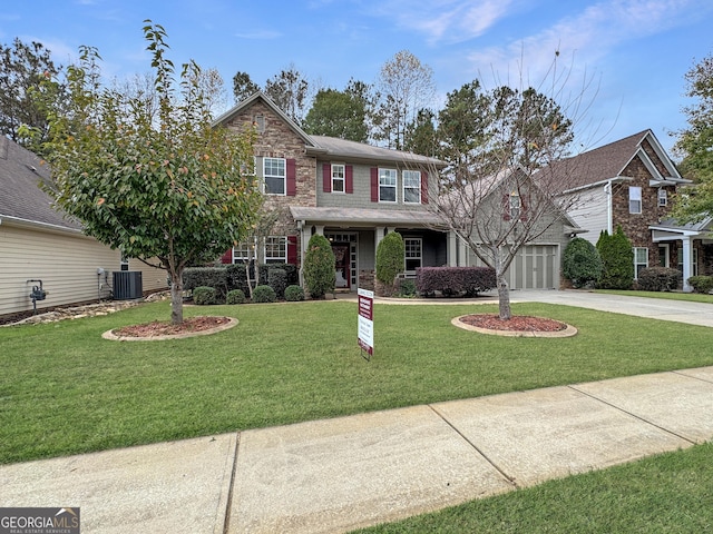 view of front of house with a porch, cooling unit, a front yard, and a garage