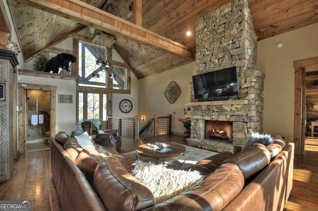 living room featuring wooden ceiling, beamed ceiling, high vaulted ceiling, hardwood / wood-style floors, and a stone fireplace