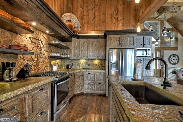 kitchen with stainless steel appliances, dark wood-type flooring, light stone counters, sink, and beam ceiling