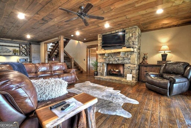 living room featuring wood-type flooring, wood ceiling, and a stone fireplace