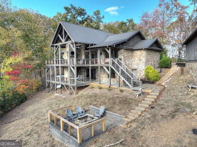 rear view of house featuring a fire pit and a deck