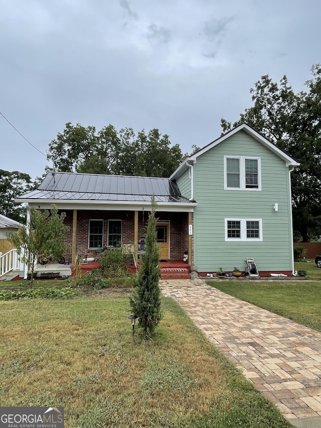 view of front of home featuring covered porch and a front lawn