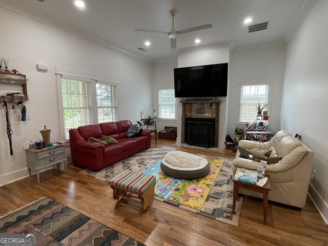 living room with ornamental molding, hardwood / wood-style floors, and ceiling fan