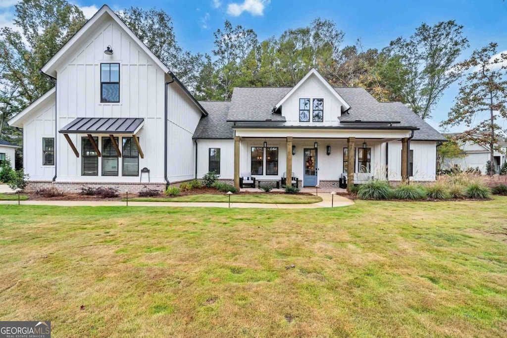 modern farmhouse style home with a front lawn and covered porch