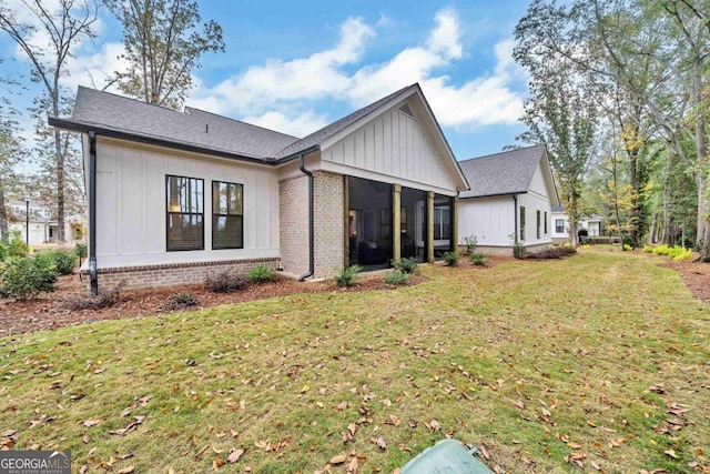 back of property featuring a sunroom and a lawn