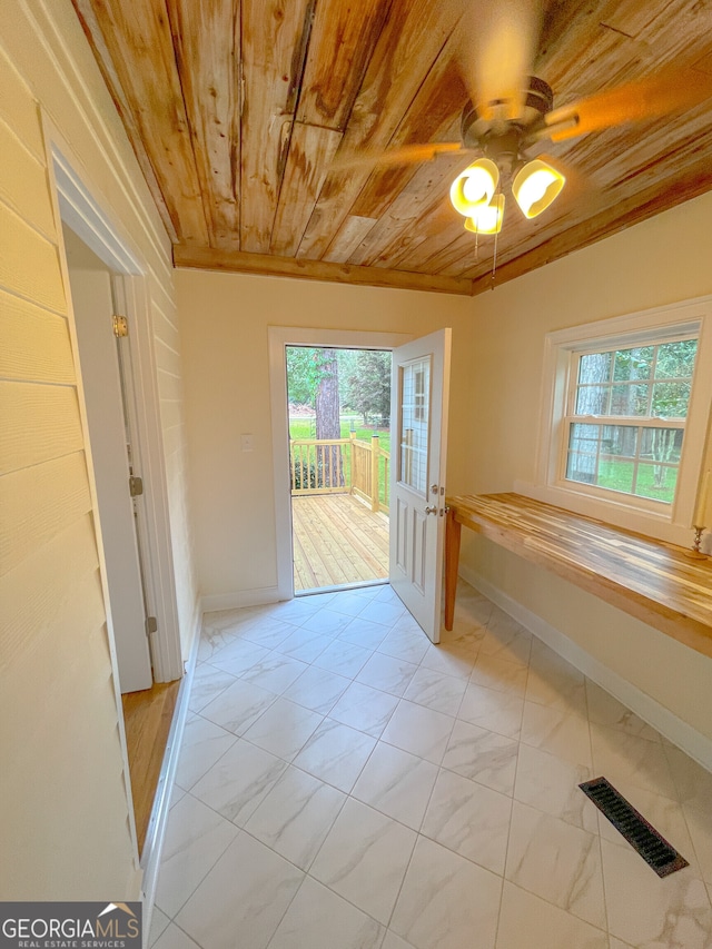 interior space with a wealth of natural light, wood ceiling, and ornamental molding