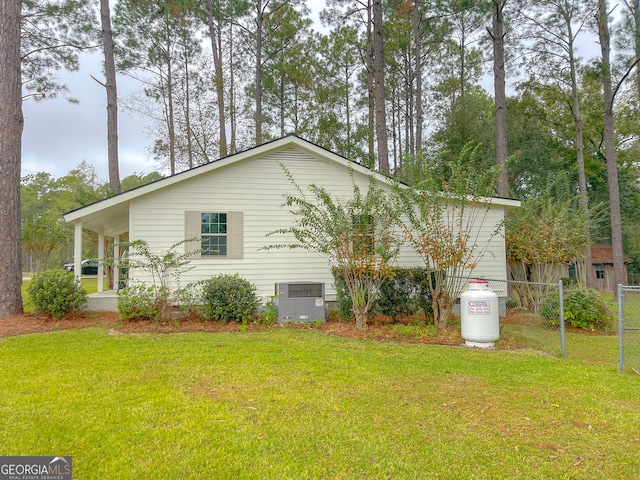 view of property exterior with central AC unit and a yard