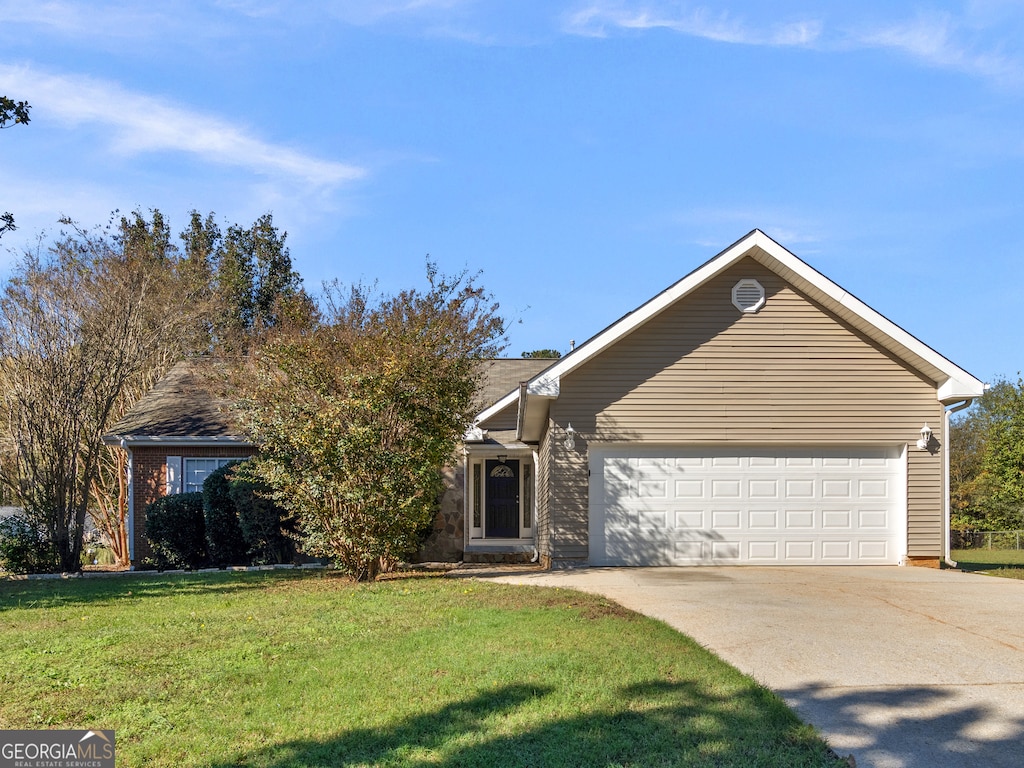 view of front of home with a front yard and a garage