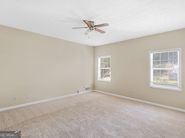 carpeted spare room with ceiling fan