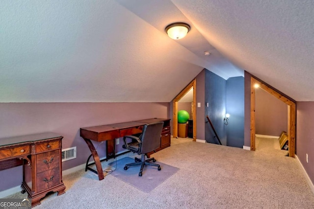 office featuring a textured ceiling, light carpet, and lofted ceiling