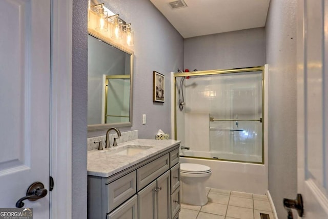 full bathroom featuring vanity, tile patterned floors, toilet, and shower / bath combination with glass door