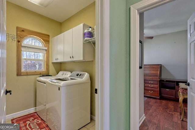 laundry area featuring dark wood-type flooring, cabinets, and washing machine and clothes dryer