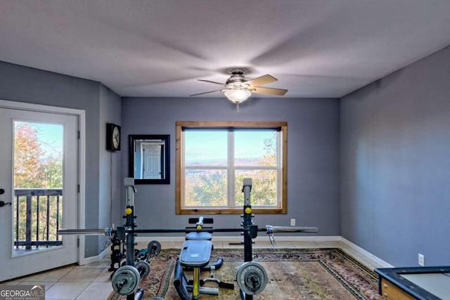 workout room with light tile patterned floors, ceiling fan, and plenty of natural light