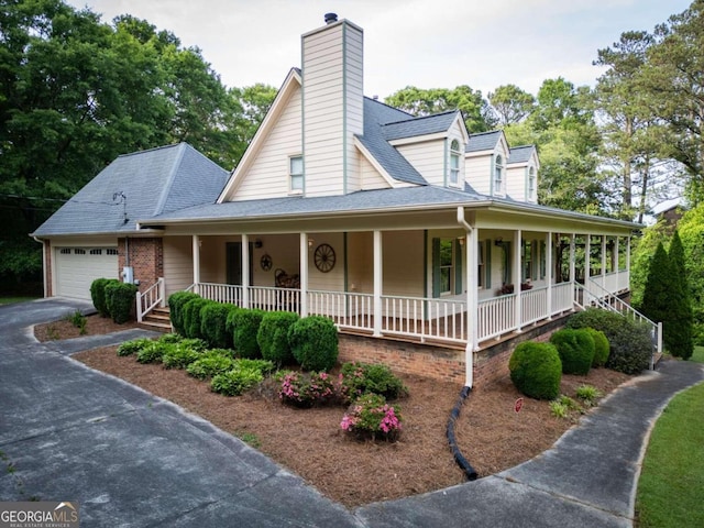 country-style home featuring a porch and a garage