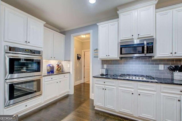 kitchen featuring stainless steel appliances, dark hardwood / wood-style flooring, decorative backsplash, ornamental molding, and white cabinetry