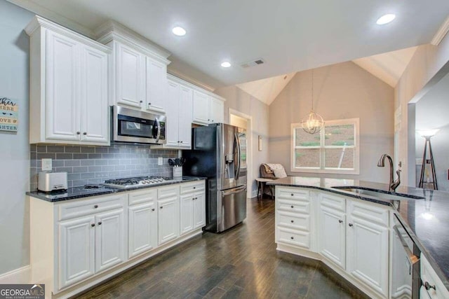 kitchen with stainless steel appliances, white cabinetry, decorative light fixtures, lofted ceiling, and dark wood-type flooring