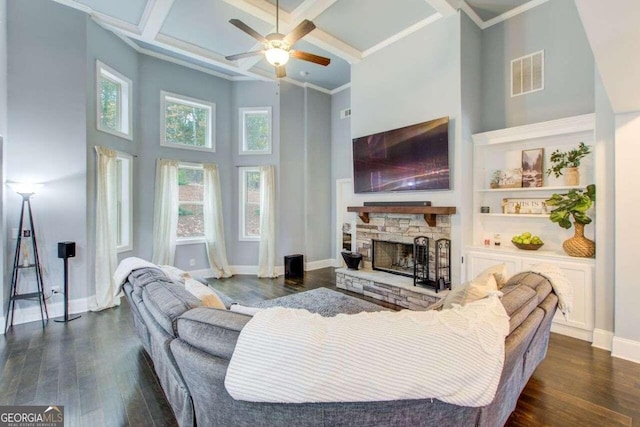 living room with a stone fireplace, coffered ceiling, ceiling fan, and dark hardwood / wood-style floors