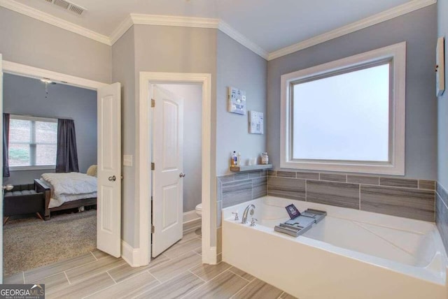 bathroom with crown molding, a washtub, and toilet