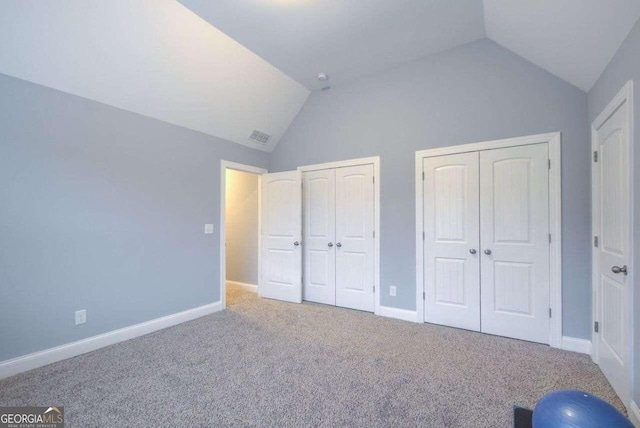 unfurnished bedroom featuring vaulted ceiling and carpet flooring