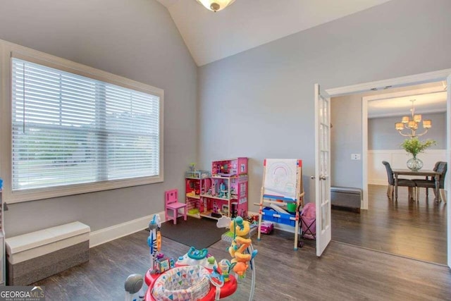 recreation room featuring a wealth of natural light, a chandelier, vaulted ceiling, and dark hardwood / wood-style flooring