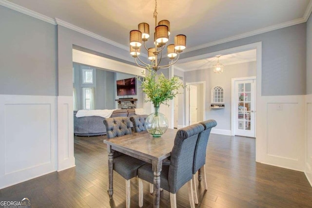 dining space featuring dark hardwood / wood-style floors, an inviting chandelier, and crown molding