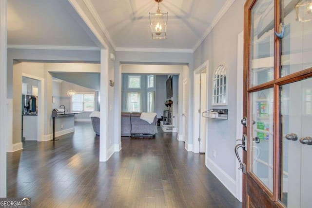 foyer with a chandelier, dark hardwood / wood-style flooring, and ornamental molding