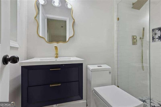 bathroom with tiled shower, vanity, and toilet