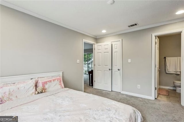 carpeted bedroom featuring ensuite bathroom, crown molding, and a closet