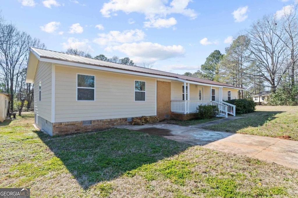 ranch-style home featuring a front lawn and covered porch