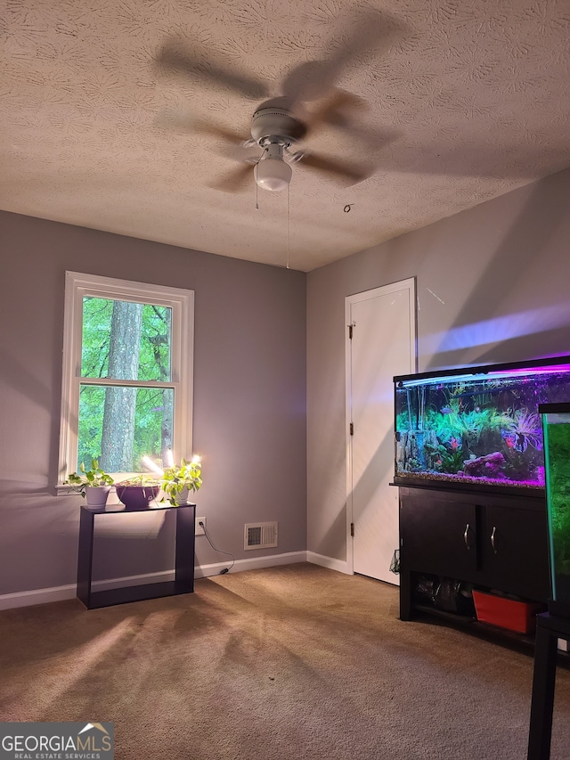 living room featuring carpet flooring, a textured ceiling, and ceiling fan