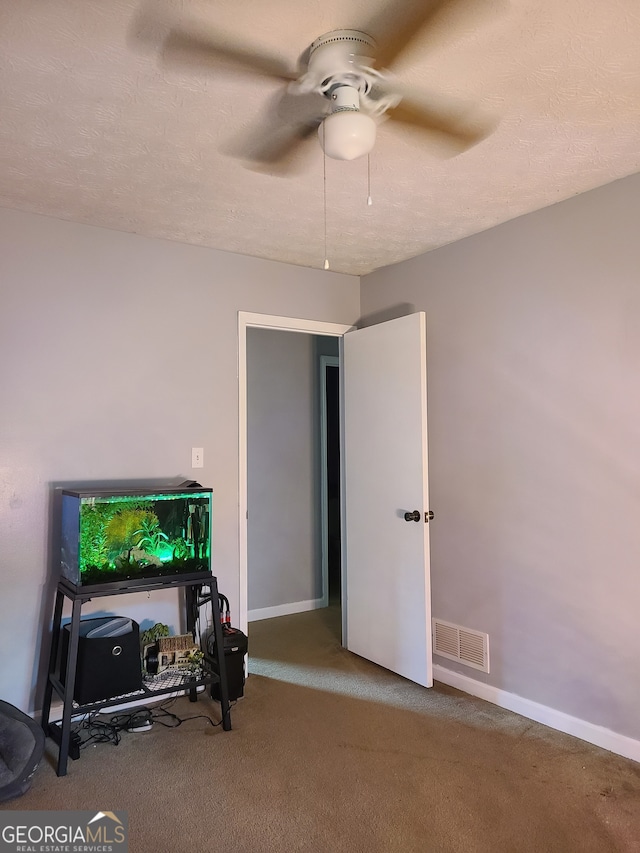 interior space with a textured ceiling and ceiling fan