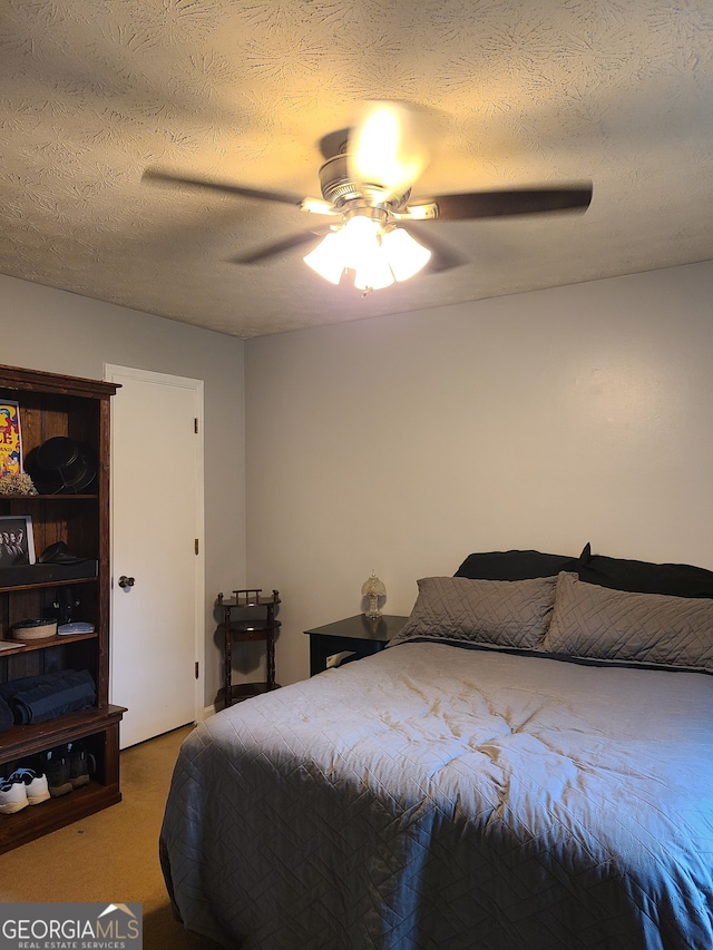 bedroom with a textured ceiling, ceiling fan, and carpet floors