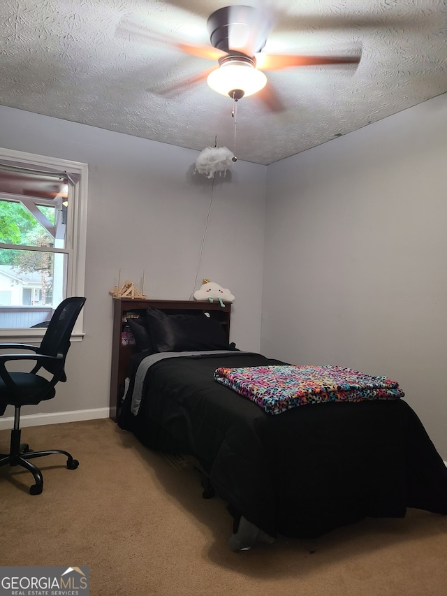 carpeted bedroom featuring a textured ceiling and ceiling fan