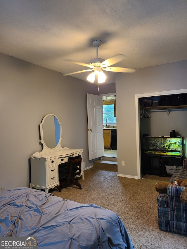 bedroom featuring a closet, sink, ceiling fan, and carpet floors