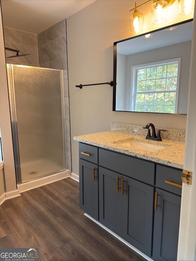 bathroom featuring vanity, an enclosed shower, and hardwood / wood-style flooring