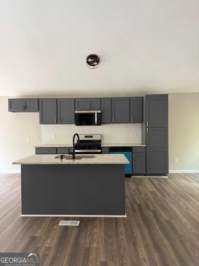 kitchen with dark hardwood / wood-style flooring, sink, stainless steel appliances, and light stone counters