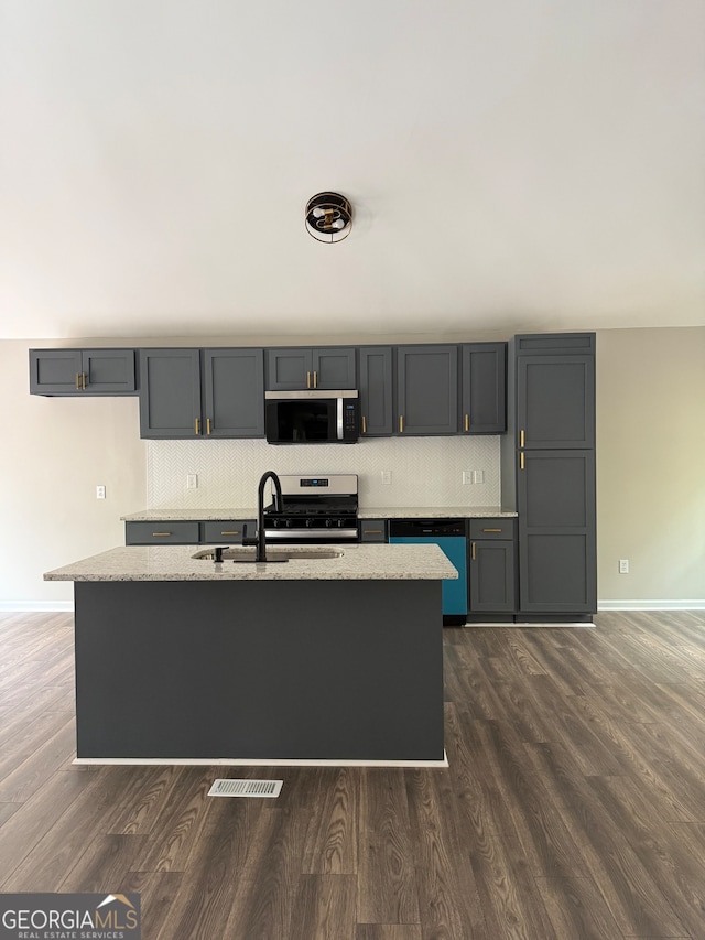 kitchen featuring sink, appliances with stainless steel finishes, light stone countertops, and dark wood-type flooring