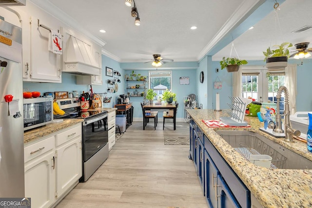 kitchen featuring visible vents, ornamental molding, a sink, white cabinetry, and stainless steel appliances