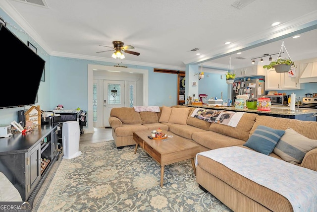 living area with visible vents, light wood finished floors, recessed lighting, ceiling fan, and ornamental molding