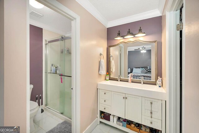 bathroom with a shower stall, toilet, vanity, and ornamental molding