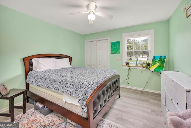 bedroom with a closet, a ceiling fan, baseboards, and wood finished floors