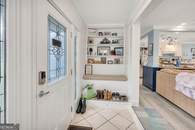 entrance foyer with crown molding and wood finished floors