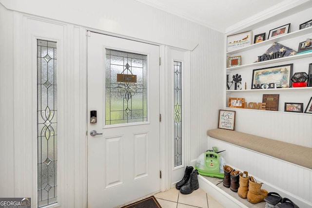 tiled entrance foyer featuring crown molding