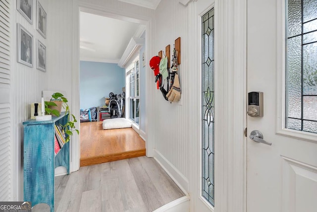 foyer with crown molding, wood finished floors, and a wealth of natural light